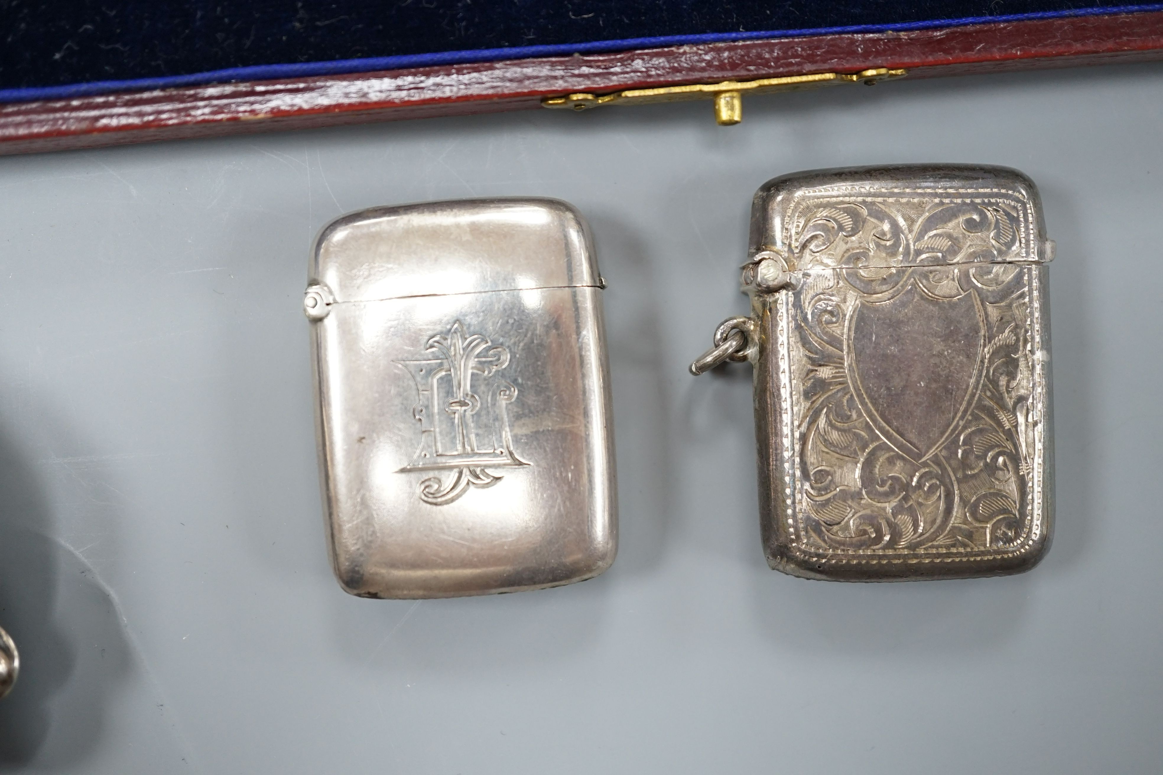 A group of small silver to include two vesta cases, a hand mirror, paste pin and a cased button hook and shoehorn.